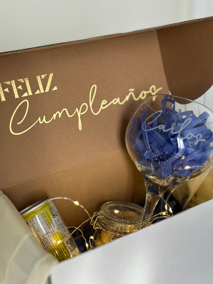 Una caja regalo para cumpleaños con una copa de cubata personalizada con el nombre 'Carlos'