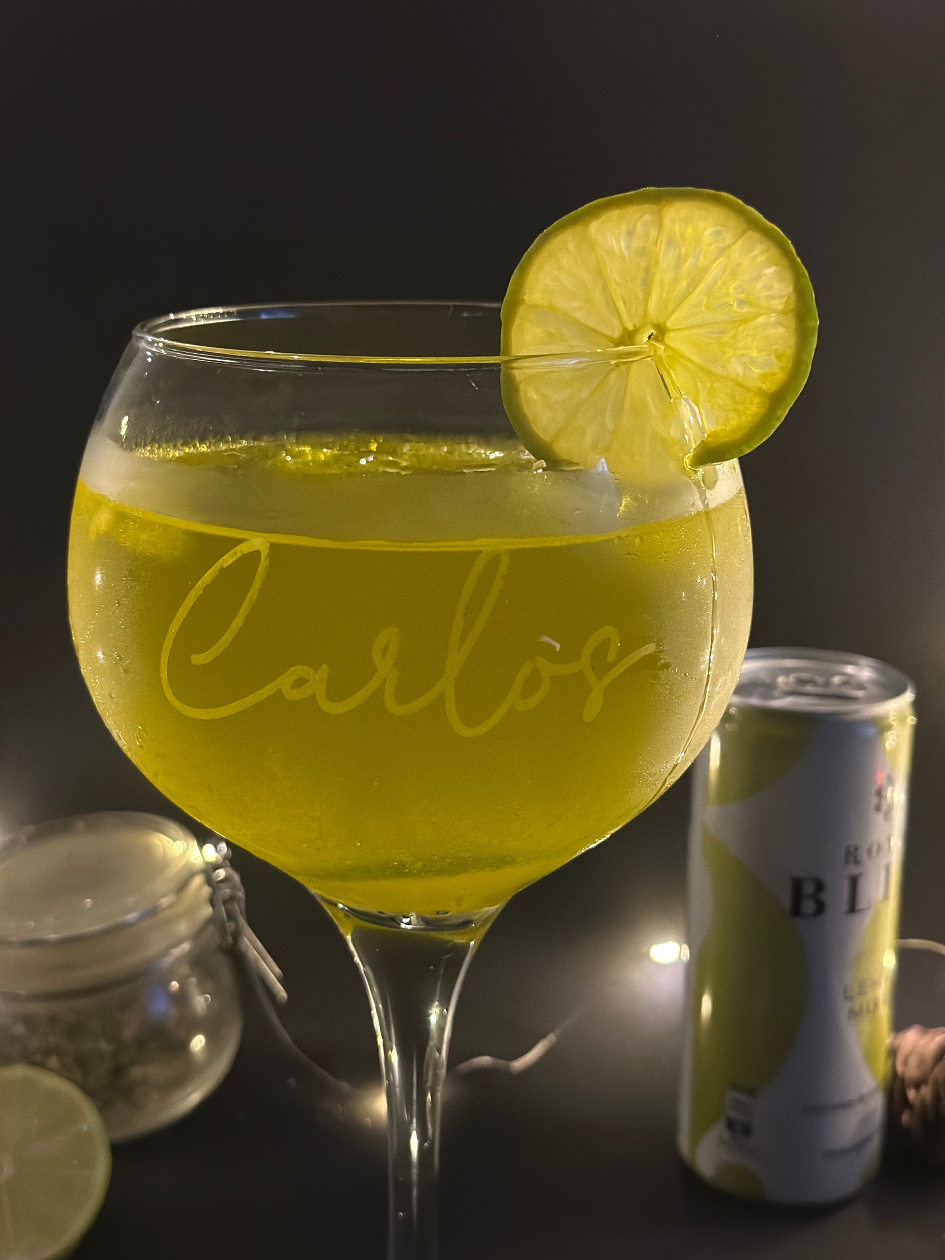 Una copa de cubata personalizado con una bebida amarilla y un trozo de limón 