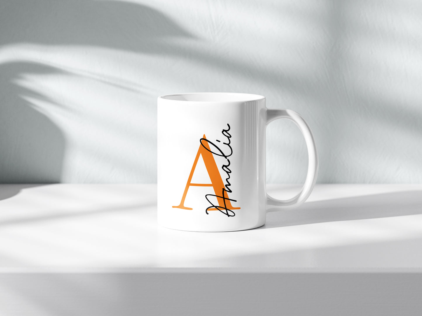 Taza personalizada con inicial en naranja y nombre en negro