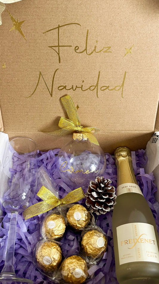 Detalle de los artículos de la caja regalo Navidad Brindis: copa grabada, cava Freixenet, bombones y adorno navideño personalizado.